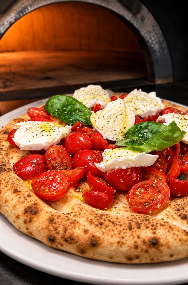 Pizza con pomodorini, mozzarella, basilico e olio